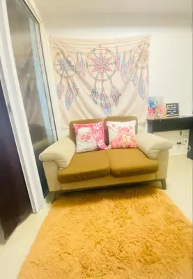a couch with two pillows in a living room at Sole Sister Azure Staycation in Manila
