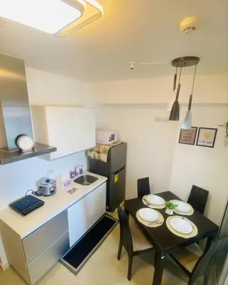 a small kitchen with a small table and a small kitchen with a table and chairs at Sole Sister Azure Staycation in Manila