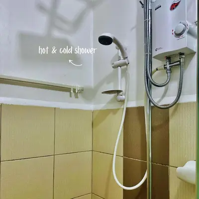 a shower in a bathroom with a hot and cold shower at Cozy Stay Near BGC & Airport in Manila