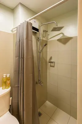 a shower with a shower curtain in a bathroom at La Casa de Maria in Manila