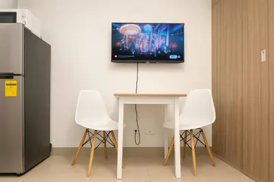 a room with a table and a tv on the wall at La Casa de Maria in Manila