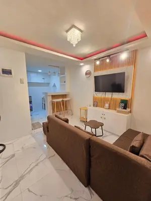 a living room with a large couch and a television at Tiny home in Naic in Naic