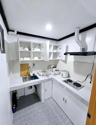 a white kitchen with white cabinets and a sink at Tiny home in Naic in Naic