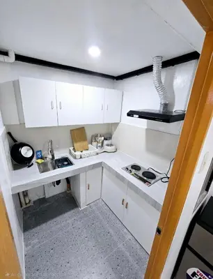 a small kitchen with white cabinets and a sink at Tiny home in Naic in Naic
