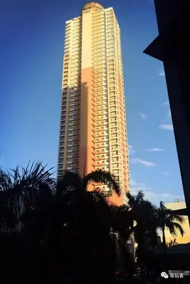 a tall building with palm trees in front of it at Birch Tower Malate Manila by T&T in Manila