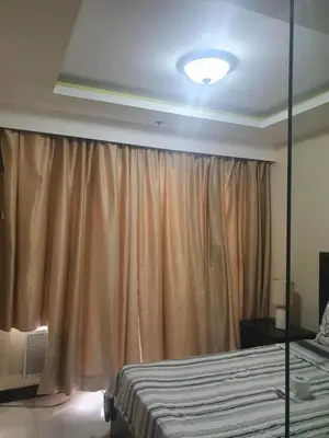 a bedroom with a bed and a large curtain at Birch Tower Malate Manila by T&T in Manila