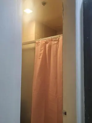 a shower with a white shower curtain in a bathroom at Birch Tower Malate Manila by T&T in Manila