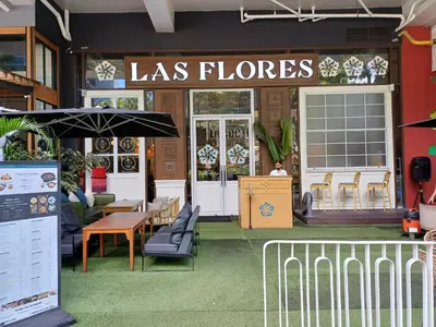 a restaurant with a sign that reads las flores at BGC High Rise, Uptown Mall Connector, 5G WiFi, Pool, Ste 15 in Manila