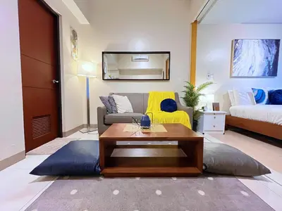 a living room with a couch and a table at BGC High Rise, Uptown Mall Connector, 5G WiFi, Pool, Ste 15 in Manila