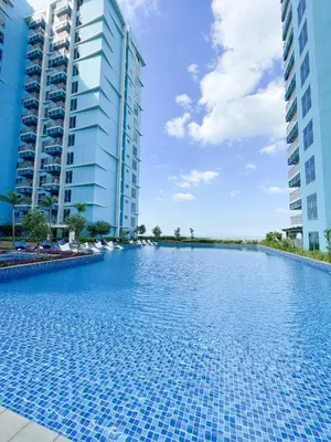 a swimming pool in the middle of two tall buildings at Cozy 3BR near Airport and Okada in Manila
