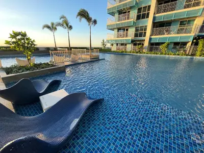 a swimming pool in front of a building at Cozy 3BR near Airport and Okada in Manila