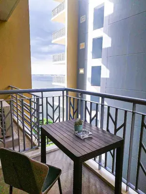 a table and chairs on a balcony with the ocean at Cozy 3BR near Airport and Okada in Manila