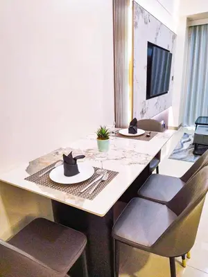 a dining table with two chairs and a hat on it at Cozy 3BR near Airport and Okada in Manila