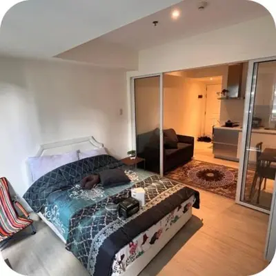 a bedroom with a bed and a living room at Staycation In Azure Parañaque in Manila