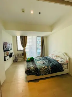 a bedroom with a bed and a large window at Staycation In Azure Parañaque in Manila