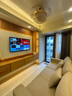 a living room with a couch and a flat screen tv at Shore 3 staycation in Manila