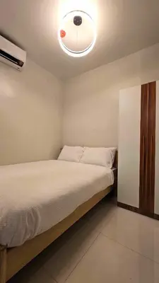 a bedroom with a bed with a ceiling fan at Shore 3 staycation in Manila