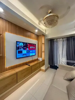 a living room with a flat screen tv on a wall at Shore 3 staycation in Manila