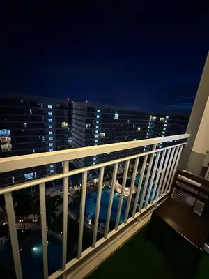 a balcony with a view of the city at night at Macc staycation in Manila