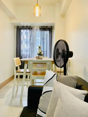 a living room with a table and a fan at SMDC Shore 3 Residences in Manila