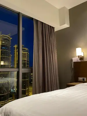 a hotel room with a bed and a large window at Amira Luxury at Novotel Suites Manila near Makati and BGC in Manila
