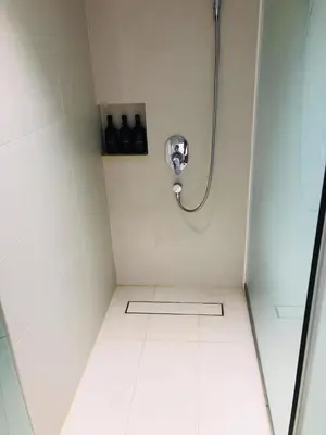 a shower in a bathroom with a tile floor at Amira Luxury at Novotel Suites Manila near Makati and BGC in Manila