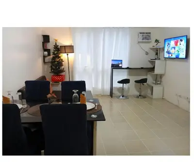 a living room with a table and chairs and a television at 2BR Pioneer Woodland connected to Metro Rail Station SM Light,BONI Mandaluyong, Metro Manila,Philippines in Manila