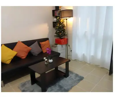 a living room with a couch and a table with a christmas tree at 2BR Pioneer Woodland connected to Metro Rail Station SM Light,BONI Mandaluyong, Metro Manila,Philippines in Manila