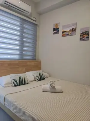 a bedroom with a large bed with a window at Reden Staycation in Manila