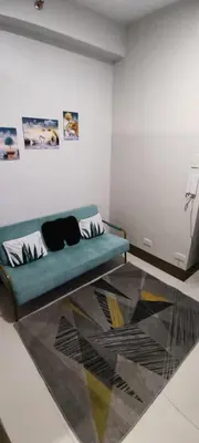 a living room with a blue couch in a room at Reden Staycation in Manila
