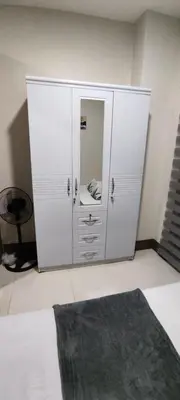 a white cabinet with a mirror in a room at Reden Staycation in Manila