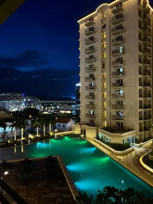 a pool in front of a building at night at Faerydae Suites - Free Pool Access in Manila