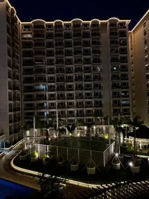 a large building with lights in front of it at night at Faerydae Suites - Free Pool Access in Manila