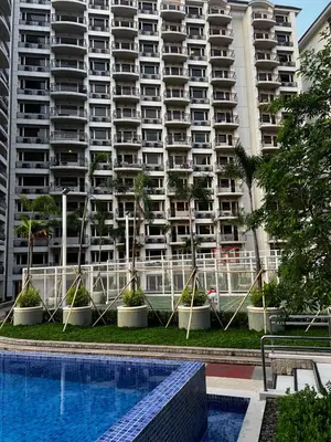 a large apartment building with a pool in front of it at Faerydae Suites - Free Pool Access in Manila