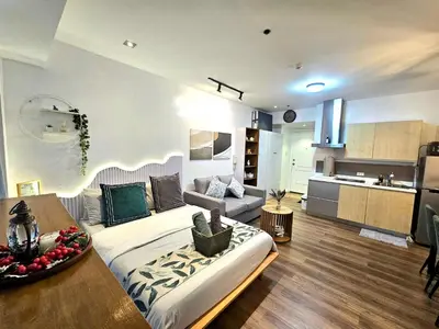 a living room with a large bed and a kitchen at Lil' Olive Spot at SOHO Central Condo in front of Edsa Shangri-la Mall in Manila