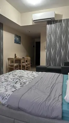 a bedroom with a large bed and a table at Cluster 6 3D 81 Newport Boulevard in Manila