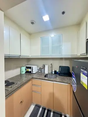 a kitchen with white cabinets and a sink at Cluster 6 3D 81 Newport Boulevard in Manila
