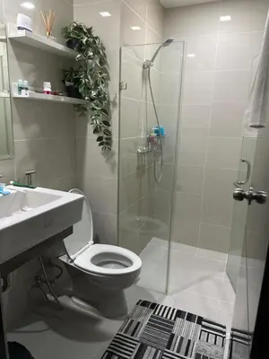 a bathroom with a shower and a toilet and a sink at Cluster 6 3D 81 Newport Boulevard in Manila