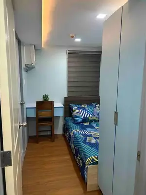 a bedroom with a bed and a chair and a table at Away from but close like family room in Manila