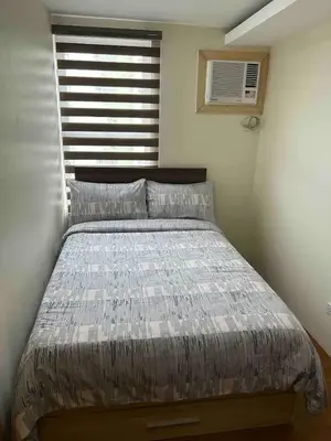 a large bed in a bedroom with a window at Away from but close like family room in Manila