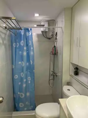 a bathroom with a shower with a blue shower curtain at Away from but close like family room in Manila
