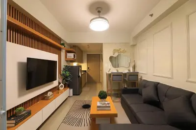 a living room with a couch and a flat screen tv at GM Suite near SM MOA, Pasay I 2 Beds I City & Bay View in Manila