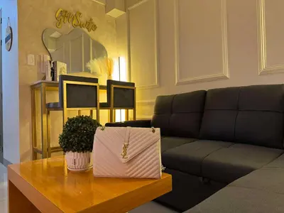a living room with a couch and a table with a purse at GM Suite near SM MOA, Pasay I 2 Beds I City & Bay View in Manila