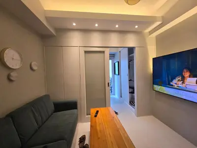 a living room with a couch and a large aquarium at Jazz Residence- Makati in Manila