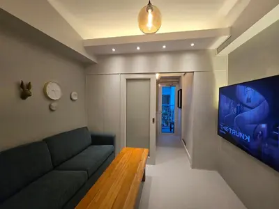 a living room with a couch and a flat screen tv at Jazz Residence- Makati in Manila