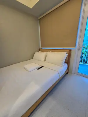 a small bed in a room with a window at Jazz Residence- Makati in Manila