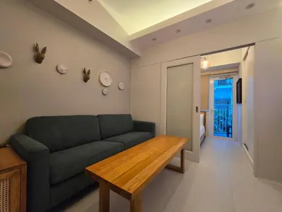 a living room with a green couch and a wooden table at Jazz Residence- Makati in Manila