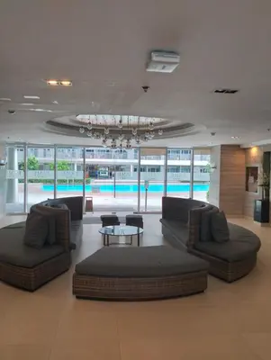 a lobby with couches and a table and a pool at Condo Ortigas CBD in Manila