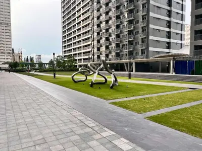 a metal sculpture in a park with tall buildings at Central Ortigas Center Condo in Manila