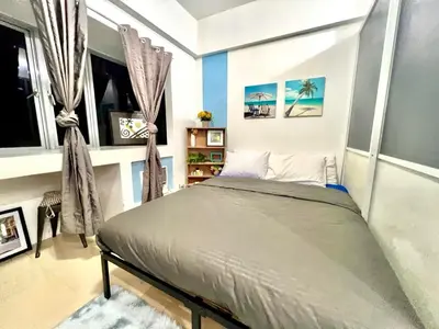 a bedroom with a bed in a room with windows at Perfect Location BGC - Mckinley in Manila